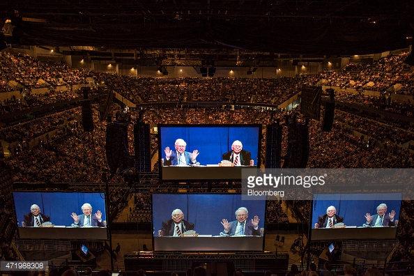 Projections of Warren Buffett, Berkshire Hathaway Inc. chairman and chief executive officer, and Charles Munger, vice chairman of Berkshire Hathaway Inc., appear on large screens above the floor of the Berkshire Hathaway Inc. annual shareholders meeting in Omaha, Nebraska, U.S., on Saturday, May 2, 2015. More than 40,000 people are expected Saturday at the Berkshire Hathaway annual meeting, which marks Warren Buffett's 50th year running the company. Photographer: Daniel Acker/Bloomberg